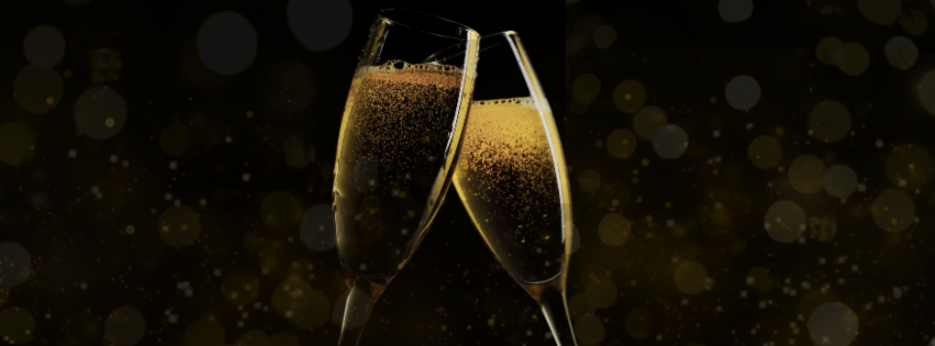 Two glasses of sparkling wine raised in a toast against a dark background.